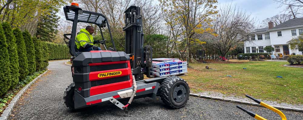 Professional roofer examining asphalt shingles for possible hail damage